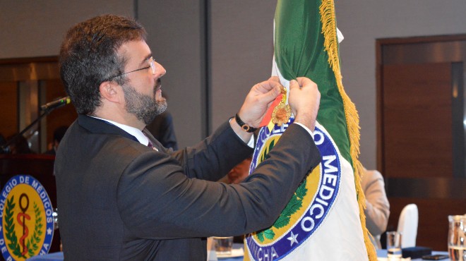 Juan Pablo Nez, CEO de UNITECO, colocando medalla en la Bandera del CMP.